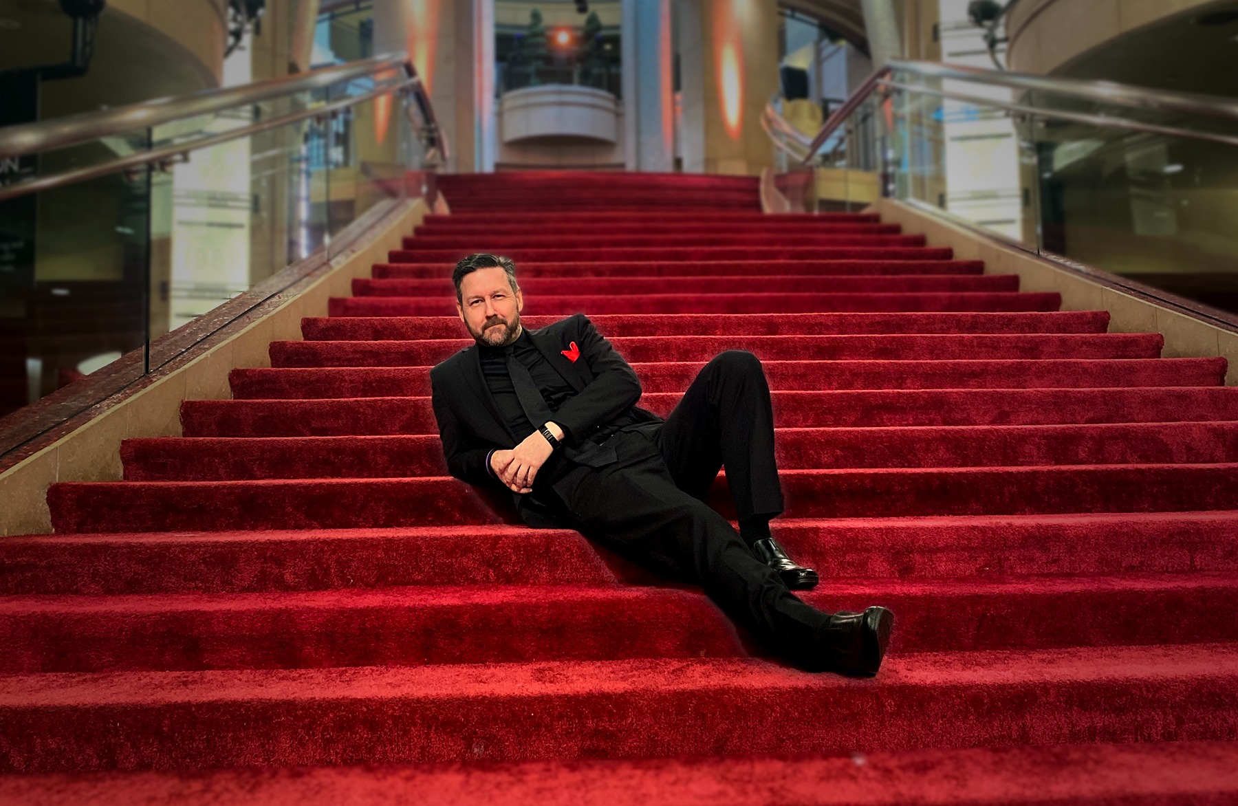 S. David Acuff in a tux on the Oscars red-carpet stairs